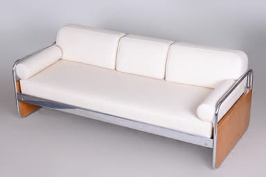 A three-seater sofa characterized by its tubular chrome frame, light wood end panels, and white upholstered cushions. The sofa features a minimalist design with a visible metal frame that extends to form the legs and back support. It includes three separate seat cushions, three back cushions, and two cylindrical bolster armrests at each end. The wood panels are integrated into the frame at the side ends. — 3D model