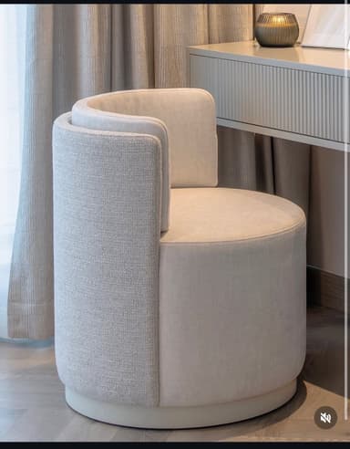 A contemporary fully upholstered barrel-back accent chair with a circular profile, featuring a slightly textured light gray fabric on the exterior and a smoother light beige fabric on the inner back and seat. The chair has a recessed circular base. — 3D model