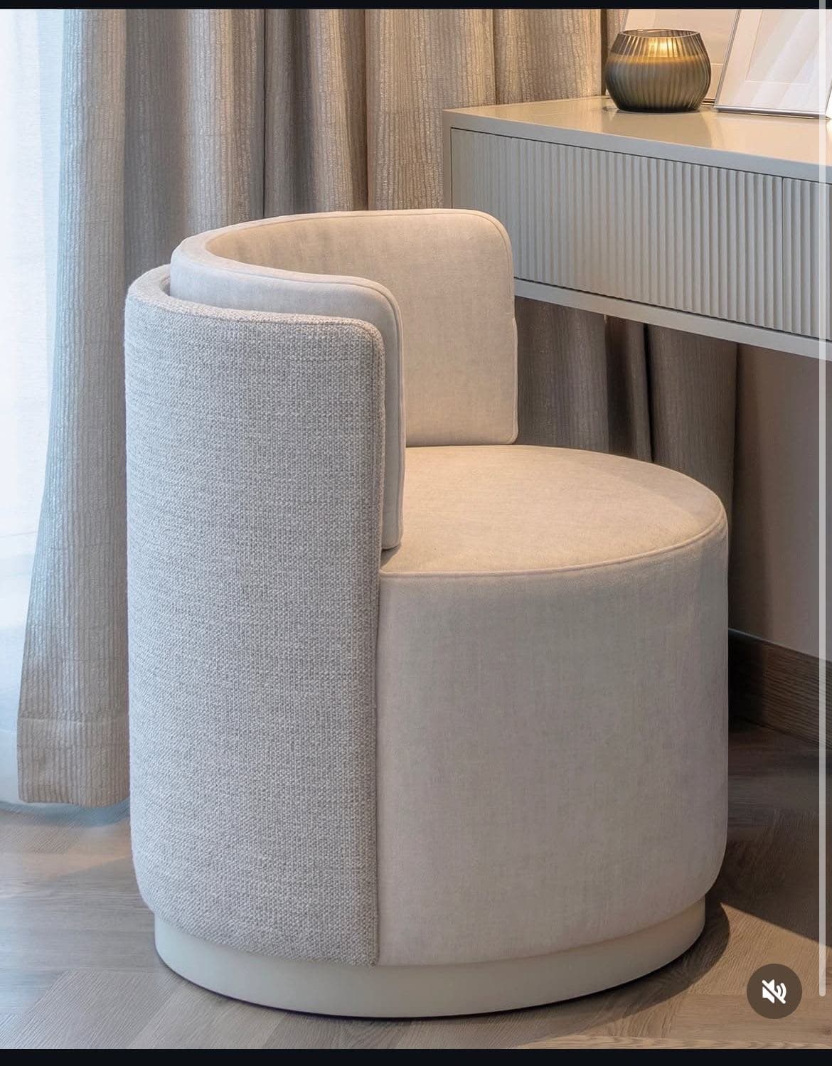 A contemporary fully upholstered barrel-back accent chair with a circular profile, featuring a slightly textured light gray fabric on the exterior and a smoother light beige fabric on the inner back and seat. The chair has a recessed circular base. — 3D model