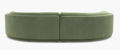 A modular, curved sectional sofa upholstered in a soft, green velvet-like fabric. The sofa features rounded edges and a layered, almost sculptural base. The design is contemporary with organic, flowing lines, suggesting a modern or art deco-inspired aesthetic. It appears to be composed of at least two connected sections to form the corner shape. — 3D model