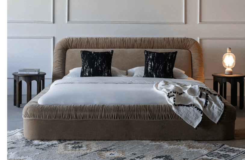 An upholstered platform bed featuring a distinctive shirred fabric detail on the headboard's perimeter and along the top edge of the side rails and footboard. The entire frame is covered in a neutral beige fabric, with a smooth central panel on the headboard contrasting with the textured shirring. The design is contemporary and low-profile. — 3D model