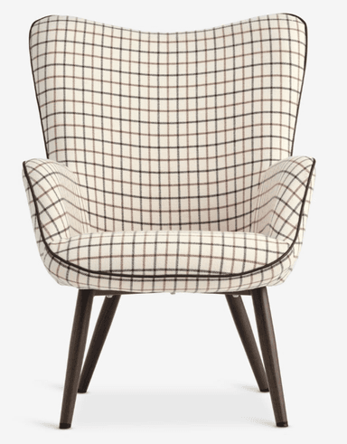 An armchair with a high, curved back and integrated armrests, upholstered in a fabric with a plaid pattern. The chair features four tapered wooden legs with protective caps at the base. — 3D model