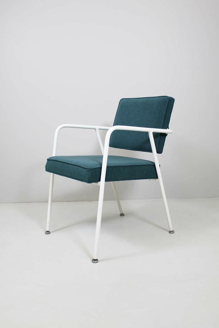 A mid-century modern armchair with a white tubular metal frame and upholstered seat and backrest in a teal-colored fabric. The armchair features a streamlined design with a slightly reclined back and integrated armrests. The legs are also made of white tubular metal and terminate in small, round feet. — 3D model