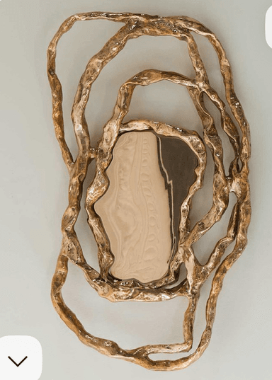 An ornate mirror with a frame resembling organic, intertwined branches or roots. The reflective surface is irregularly shaped, contained within the sculpted frame. — 3D model