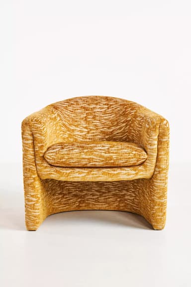 A standalone armchair with a rounded back and seat. The upholstery features a textured pattern in shades of yellow and cream, resembling an abstract animal print or natural fibers. — 3D model