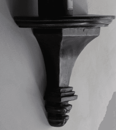 A dark brown, semi-circular wall shelf with a decorative, carved bracket. The shelf has a subtle curved edge and the bracket features multiple tiered elements, tapering towards the bottom with a rounded finial. — 3D model