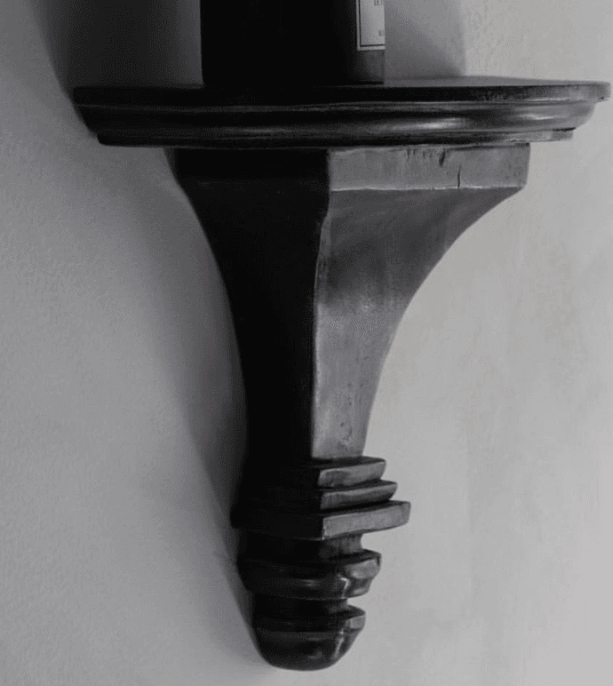 A dark brown, semi-circular wall shelf with a decorative, carved bracket. The shelf has a subtle curved edge and the bracket features multiple tiered elements, tapering towards the bottom with a rounded finial. — 3D model