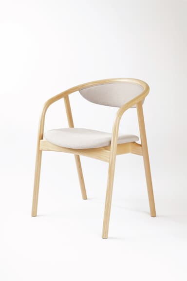 A modern armchair constructed with a light-toned wooden frame and upholstered seat and backrest. The frame features smoothly curved armrests and back support. The design is minimalist and contemporary, with slender, tapered legs. — 3D model