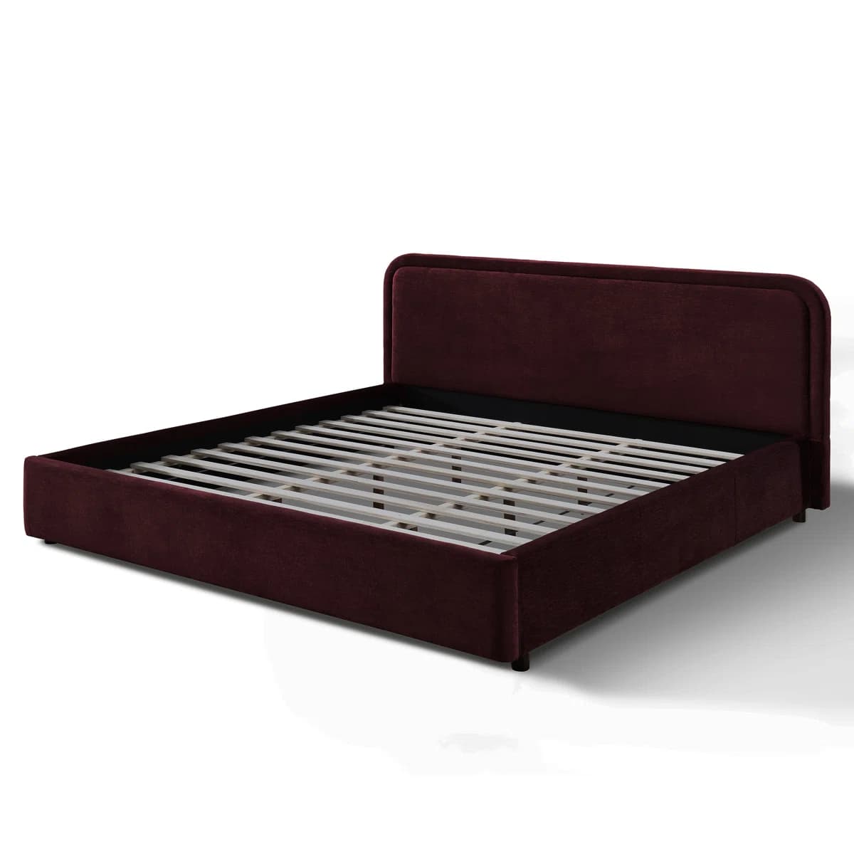 A modern platform bed frame featuring a fully upholstered headboard and side rails in a dark red or burgundy velvet-like fabric. The headboard has a simple, rounded design, and the frame includes wooden slats for mattress support, eliminating the need for a box spring. It stands on small, discreet black feet, presenting a low-profile aesthetic. — 3D model