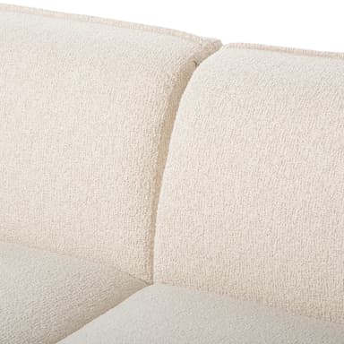 A modular sectional sofa with a curved, organic design. It features a plush, textured upholstery in a light cream or off-white color and sits on small, dark metal legs. The sofa appears to be composed of at least two sections, one with an extended chaise lounge. — 3D model