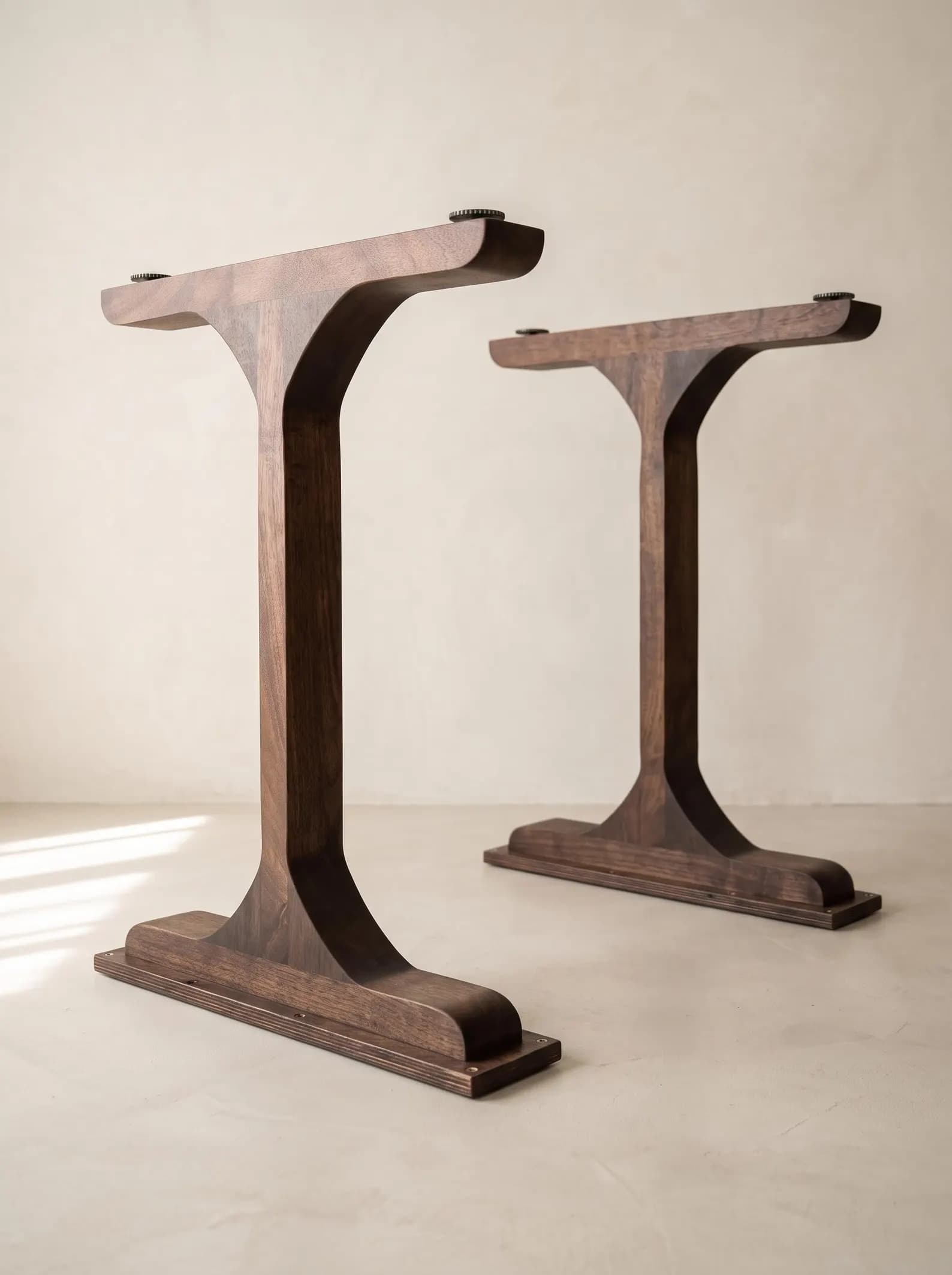 A modern T-shaped table base crafted from dark-stained wood, featuring a central column flaring into a flat rectangular top with adjustable metal connectors and a sturdy footplate. — 3D model