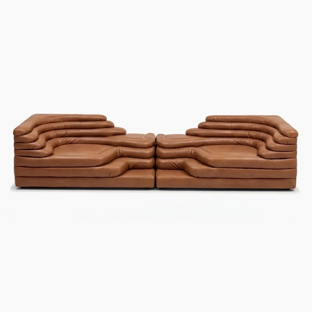 A modular, low-profile sofa composed of two symmetrical sections, each featuring a unique, layered design with undulating horizontal lines. The sofa is upholstered in brown leather and appears to be a contemporary or postmodern piece with a sculptural quality. — 3D model