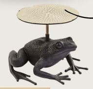 A unique sculptural side table featuring a dark, textured cast metal frog as its base, supporting a round, light-colored tabletop with a radiating pattern, connected by a brass-toned rod. — 3D model
