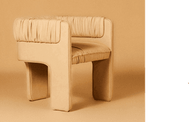 A contemporary armchair featuring a distinctive ruched and gathered upholstery design, rendered in a warm, light tan color. The chair has a boxy, monolithic silhouette with integrated armrests and a continuous upholstered base, giving it a sculptural and cohesive appearance. The soft, textured fabric adds a tactile element to its modern form. — 3D model