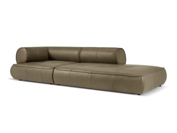 A modern chaise lounge sofa with a tufted seat cushion and a rounded armrest/headrest. The sofa features clean lines and a low profile, upholstered in a smooth, matte-finish material. — 3D model