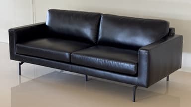 A modern two-seater loveseat upholstered in black leather, featuring a clean, minimalist design. It has two distinct seat cushions and two back cushions, straight square arms, and is supported by four slender, dark-finished metal legs that provide a floating appearance. — 3D model