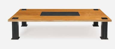 A rectangular coffee table featuring a light-toned wooden top with a central, recessed black inlay. The table is supported by four robust, square-sectioned black metal legs, which are visibly attached to the tabletop with square black metal corner brackets. — 3D model