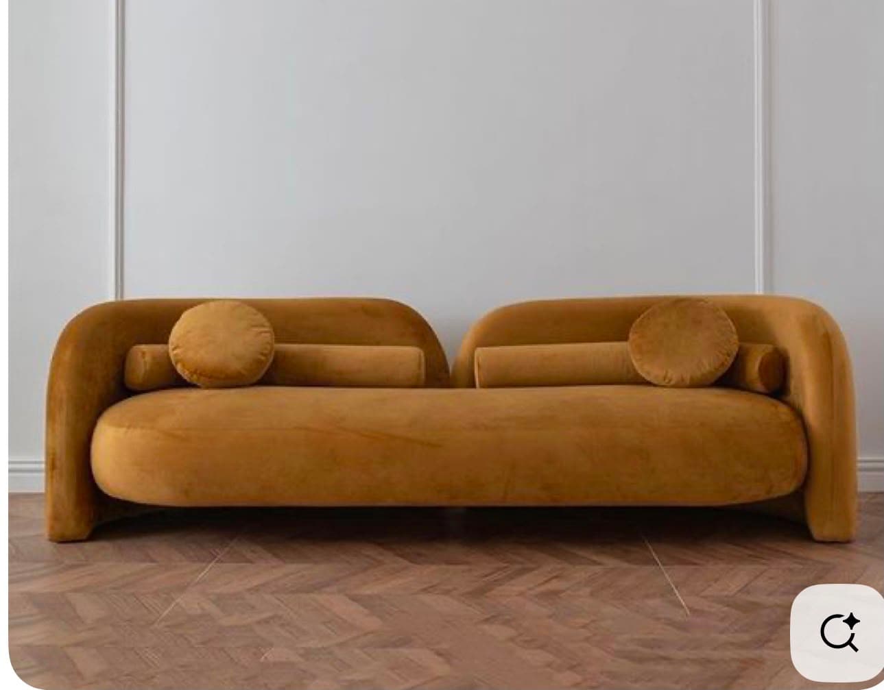 A long, curved, asymmetrical upholstered seating unit in golden-yellow velvet, featuring an integrated back and armrest design, accompanied by bolster and round accent cushions. — 3D model