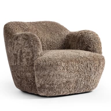 A plush, upholstered armchair with a rounded, organic silhouette. The piece features a thick, textured covering resembling sheepskin or a similar natural fiber, providing a soft and inviting appearance. The armrests are integrated into the body of the chair, flowing seamlessly into the back and seat. The base is low and broad, contributing to its sturdy and comfortable design. — 3D model