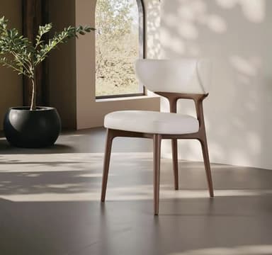A modern armless dining chair featuring a curved, upholstered backrest and seat, supported by a dark stained wooden frame and slender tapered legs. — 3D model