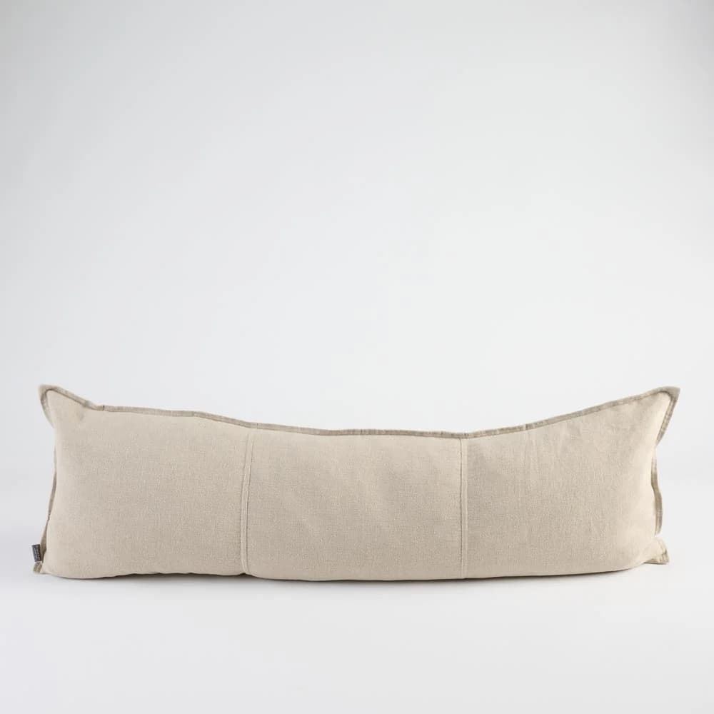 A long, rectangular bolster pillow made from a light beige woven fabric, featuring piped edges and subtle segmentation stitches across its body. The pillow is shown against a plain white background. — 3D model