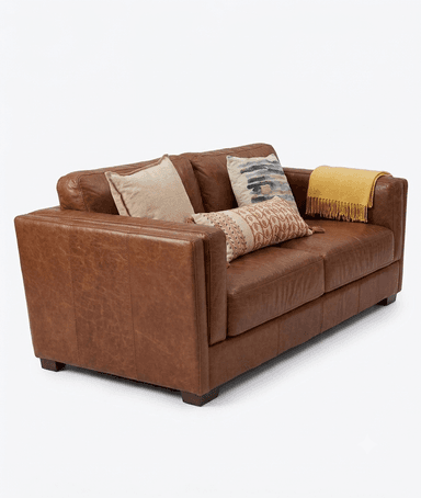 A three-seater sofa upholstered in rich, reddish-brown leather, featuring a contemporary design with clean lines and square track arms. It has a two-over-two cushion configuration with two plush seat cushions and two back cushions. The leather exhibits some natural variations and slight distressing, contributing to a lived-in aesthetic. The sofa rests on low, dark block feet and is accessorized with three decorative throw pillows and a yellow throw blanket. — 3D model
