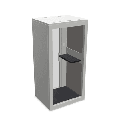 A compact, freestanding booth with a modern, minimalist design. It features a glazed front panel for entry, allowing natural light and visibility. Internally, it is equipped with a dark-colored floor mat and a cantilevered shelf, suggesting a functional space for temporary use like phone calls or focused work. The exterior is finished in a neutral gray tone, and the construction appears to be panel-based. — 3D model