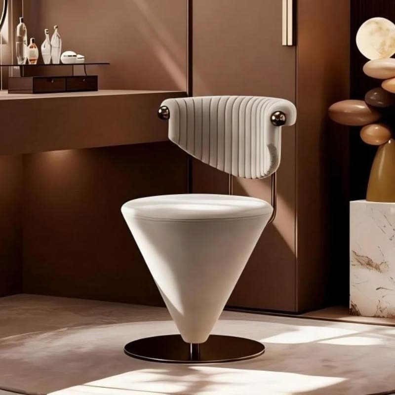 A contemporary chair featuring a unique conical pedestal base in a bronze-toned metallic finish, supporting a circular, upholstered seat. The chair's backrest is distinctly curved with vertical channel tufting, also upholstered in a light cream or off-white fabric. The backrest is connected to the base by slender, dark metallic rods, adorned with small spherical metallic finials at its ends. The overall design is elegant and modern, with luxurious details. — 3D model