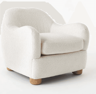 A contemporary armchair fully upholstered in a cream-colored bouclé fabric, featuring a soft, rounded silhouette. The chair has a deep seat with a removable cushion and gently curved armrests and backrest, all contributing to a plush and inviting appearance. It stands on four short, cylindrical, light-toned wooden legs. — 3D model