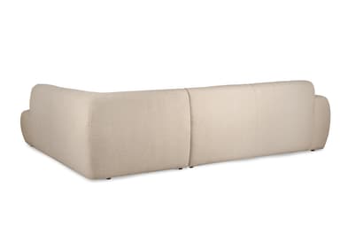 An L-shaped contemporary sectional sofa upholstered in a light cream bouclé fabric. The sofa features a long three-seat section combined with an integrated chaise lounge on the right, providing ample seating. Its design is characterized by soft, rounded edges on the arms and back, and a low-profile silhouette with minimalist dark feet. The cushions appear integrated, creating a seamless and inviting aesthetic. — 3D model