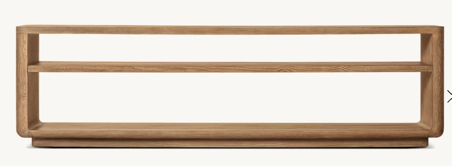 A low, elongated wooden console shelf with a minimalist design, featuring two horizontal tiers. The unit is constructed from light-colored wood with visible grain, and all edges are softly rounded, creating a smooth, continuous silhouette. It rests on a slightly recessed plinth base. — 3D model
