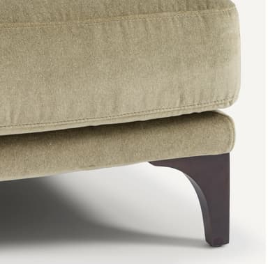 A contemporary sofa with a plush, upholstered finish. It features a three-seat configuration with deep cushions and multiple throw pillows for added comfort. The sofa is supported by dark, tapered legs, suggesting a modern or mid-century modern aesthetic. The upholstery appears to have a soft texture, possibly velvet or a similar fabric. — 3D model