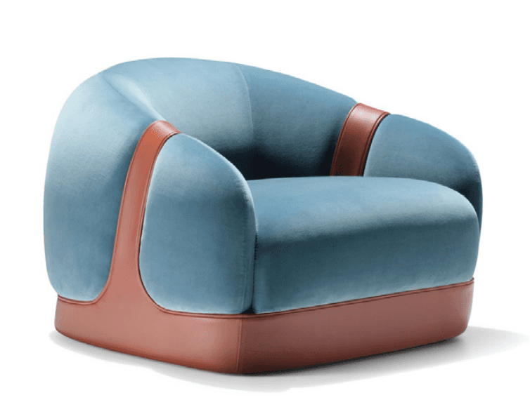 A contemporary single-seater armchair featuring a rounded, embracing silhouette. It is upholstered in a soft blue velvet, contrasted by prominent brown leather elements. The leather forms a wide strap over the exterior of the arms and extends down to form a solid, rectangular base for the chair. — 3D model