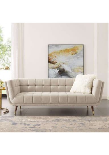 A contemporary sofa featuring a channel-tufted design on the seat and backrest, with a neutral-toned fabric upholstery. It has clean, straight track arms and is supported by four slender, splayed legs with brass caps. The overall aesthetic is minimalist and modern, with a nod to mid-century design. — 3D model