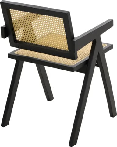A modern armchair with a black wooden frame and cane weaving for the seat and backrest. The armchair features a distinctive angular design with a sloped backrest and armrests, supported by four angled legs. — 3D model
