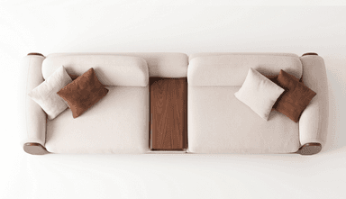 A contemporary upholstered armchair, featuring thick, rounded cushioning in a textured, off-white fabric. The chair incorporates dark wooden side panels that run vertically along its exterior. A loose, rectangular brown accent pillow rests against the back cushion, adding a touch of contrast. The design emphasizes comfort and a minimalist aesthetic. — 3D model
