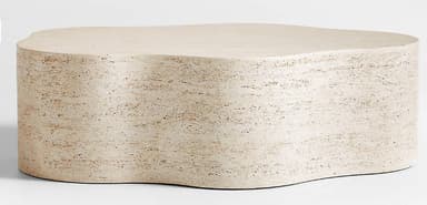A modern, sculptural coffee table crafted entirely from light-colored travertine stone. Its distinctive feature is an elongated, undulating top and base, creating an organic, wavy silhouette. The surface and sides are smooth with visible natural pores inherent to travertine, exhibiting a natural, matte finish. The piece appears monolithic and robust, designed as a singular, continuous form. — 3D model