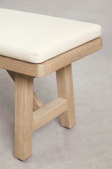 A minimalist bench with a light wood frame and a cream-colored cushioned seat. The frame features a simple, angular design with two A-frame legs connected by a horizontal support. The cushioned seat appears to be upholstered. — 3D model