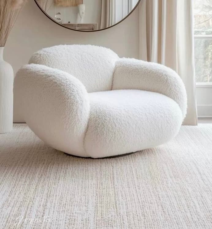 A contemporary lounge chair upholstered in a soft, white bouclé fabric, featuring a rounded, plush silhouette with integrated arms and a visible swivel base. The design is modern and minimalist, prioritizing comfort and a sculptural aesthetic. — 3D model
