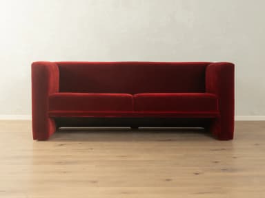 A two-seater sofa with a distinct geometric design. It features deep red velvet upholstery, high, angular armrests that extend downwards to form the base, and a single seat cushion. — 3D model