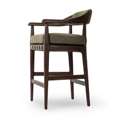 A bar stool with a wooden frame and upholstered seat and backrest. The frame is constructed from dark wood with visible grain. The seat and backrest are upholstered in a textured, olive-green fabric. The stool has a curved backrest that extends to armrests, and its legs are supported by crossbars. — 3D model