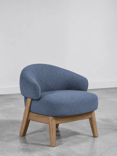 A single-seater chair featuring a rounded, continuous backrest and armrests, upholstered in a textured blue fabric, and supported by four splayed wooden legs. — 3D model
