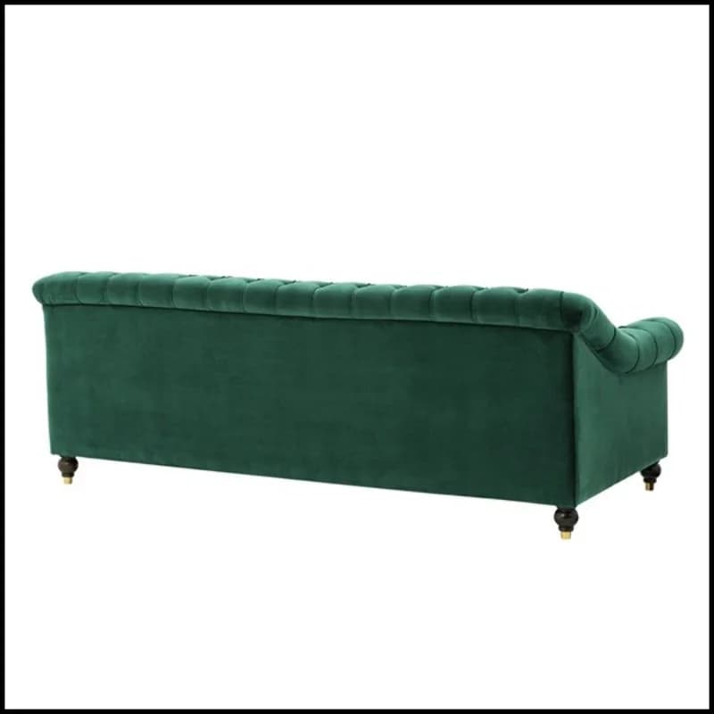 A velvet upholstered sofa with deep button tufting along the back and arms. The sofa features rolled arms and sits on short, decorative wooden legs with brass accents. The back is tufted and curves slightly outwards. The color is a rich emerald green. — 3D model