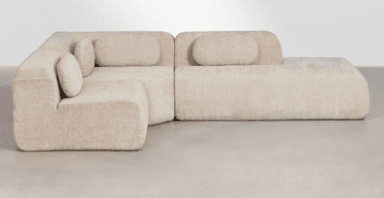 An L-shaped modular sectional sofa in a light beige, textured fabric, featuring soft, rounded edges and separate, integrated back cushions. The design is low-profile and contemporary, emphasizing comfort and an organic aesthetic. — 3D model