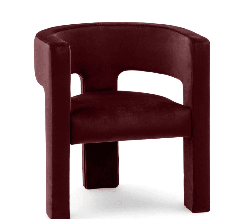 A contemporary armchair fully upholstered in a dark red (burgundy) velvet fabric, featuring a barrel-shaped back and integrated armrests with a cut-out detail, and thick upholstered block legs. — 3D model