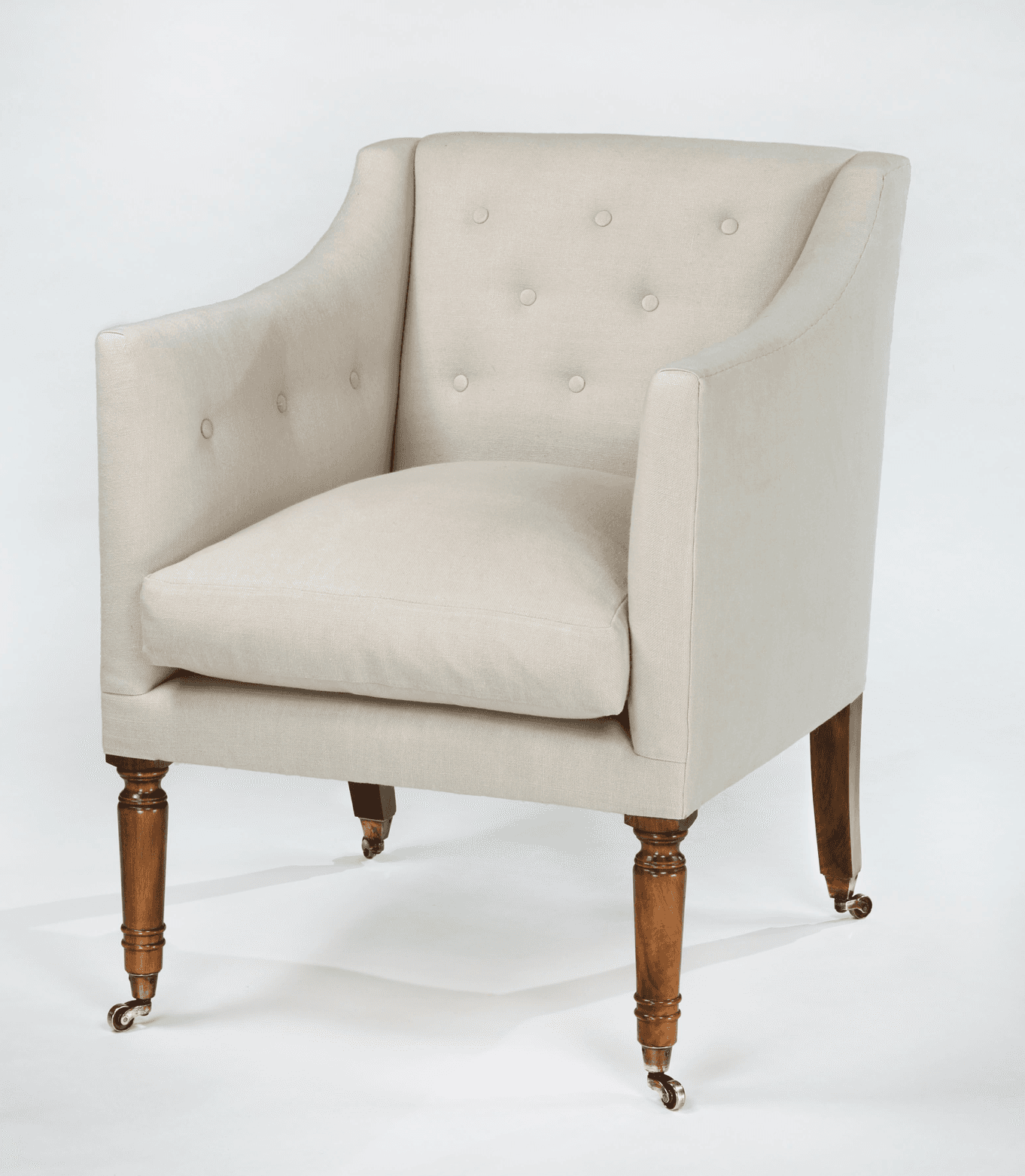 A tufted armchair with a high back and rolled arms, upholstered in a light-colored fabric. It features wooden legs with brass casters. — 3D model