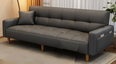 A modern sofa bed upholstered in dark grey faux leather, featuring distinctive grid-pattern tufting across both the seat and backrest. It has clean, straight armrests with integrated storage pockets on one side, and is supported by four tapered wooden legs. A matching throw pillow is included, resting on the seat. The design is contemporary and minimalist, indicating a convertible function. — 3D model