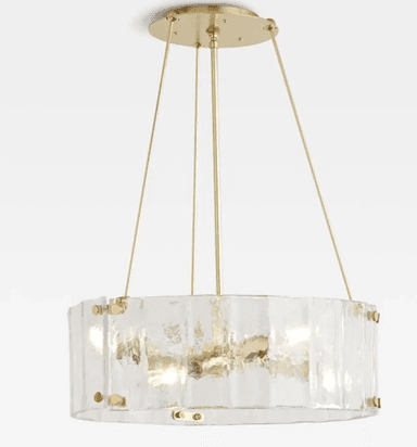 A close-up view of a modern chandelier featuring a circular arrangement of multiple exposed bulbs within a distinctive textured glass shade. The frame and bulb sockets are made of polished brass. The translucent glass shade has an irregular, possibly octagonal or faceted shape, and appears to be made of 'seedy' or artisanal glass, secured by visible brass fasteners around its upper edge. — 3D model