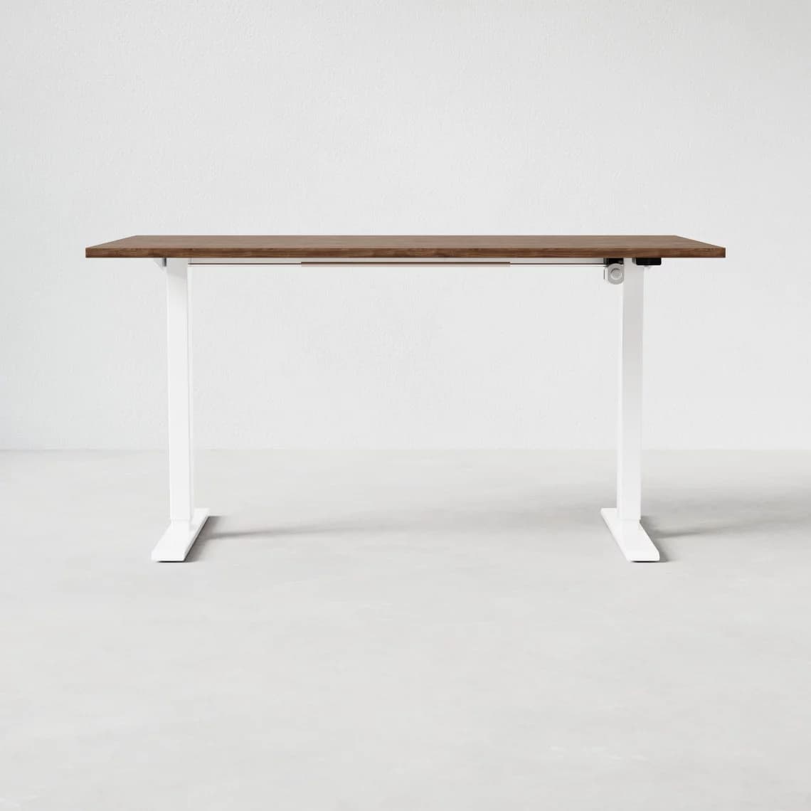A modern standing desk with a rectangular, wood-grain finished top and white, adjustable legs. The legs have a curved, minimalist design with a flat base for stability. A visible mechanism on the right leg suggests height adjustability. — 3D model