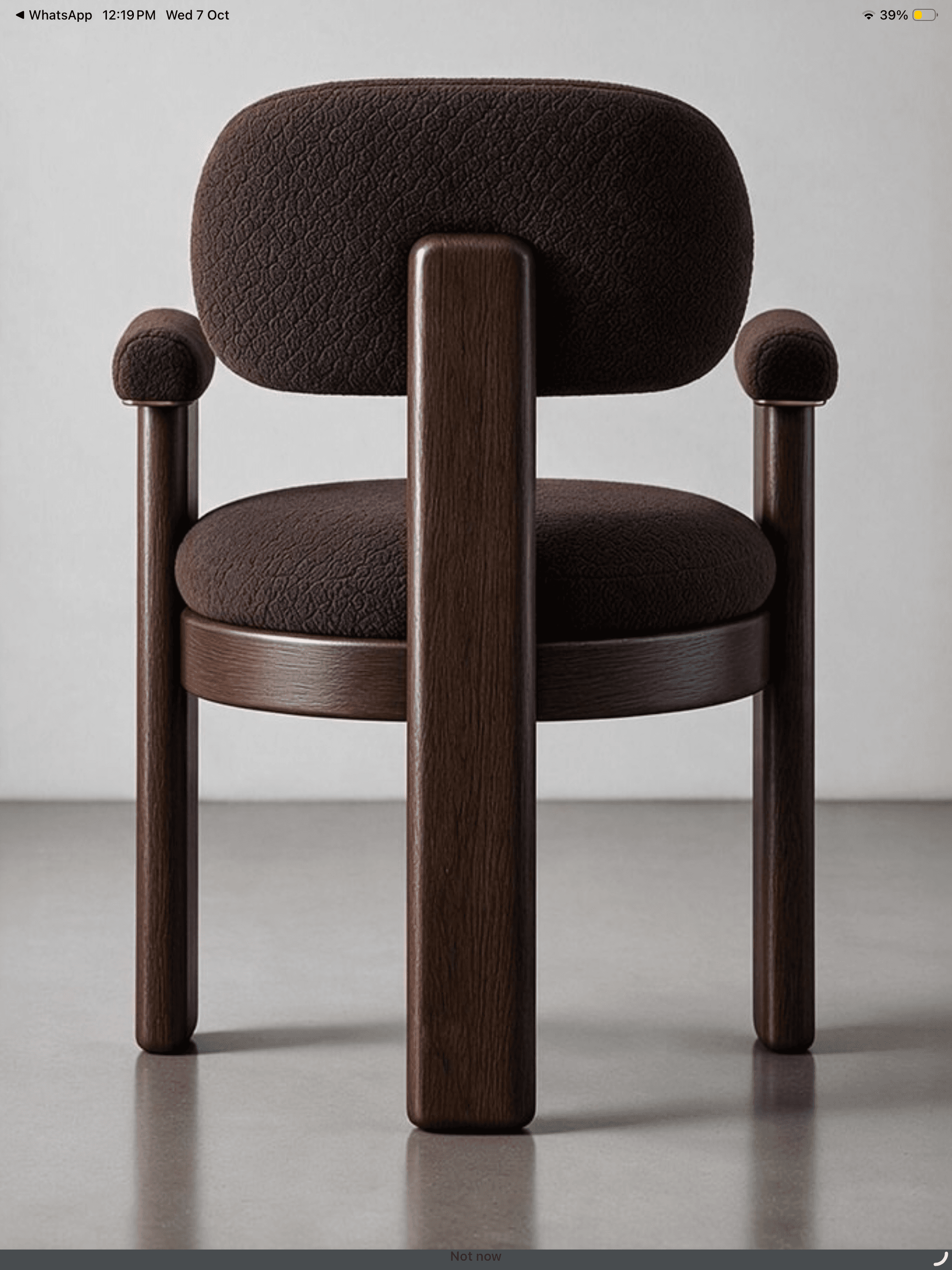A contemporary dark wood armchair featuring a robust frame and plush, rounded upholstered components. The chair has a dark brown textured fabric on its seat, backrest, and rounded armrests. The sturdy wooden legs and back support are also dark-stained, creating a cohesive, modern aesthetic. — 3D model